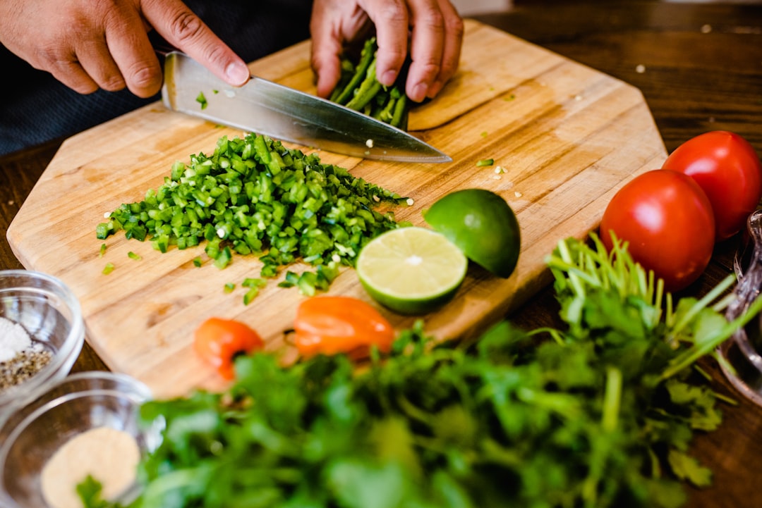 Professional chef's knife slicing through fresh vegetables on cutting board