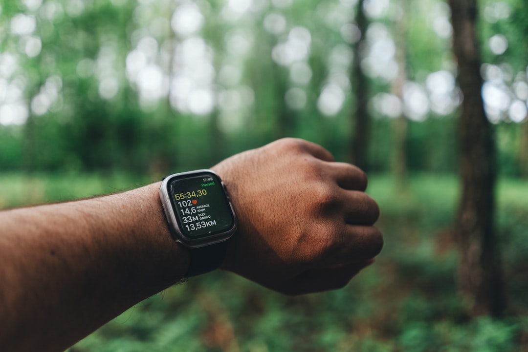 Runner with Garmin watch checking metrics on trail run