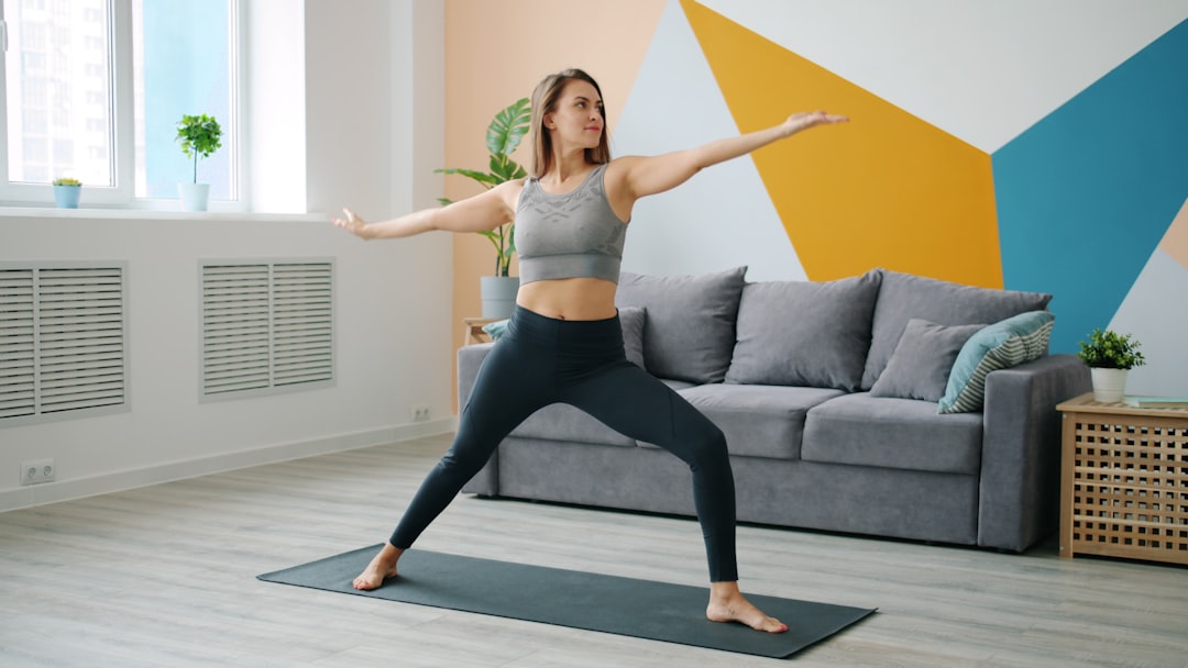 Woman in warrior II pose on colorful yoga mat