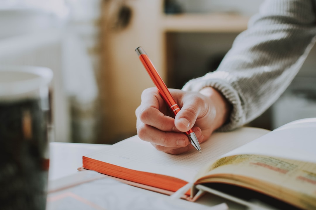 Woman writing in a wellness journal at a wooden table