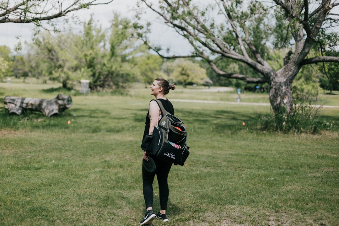 Woman walking with weighted backpack outdoors in summer