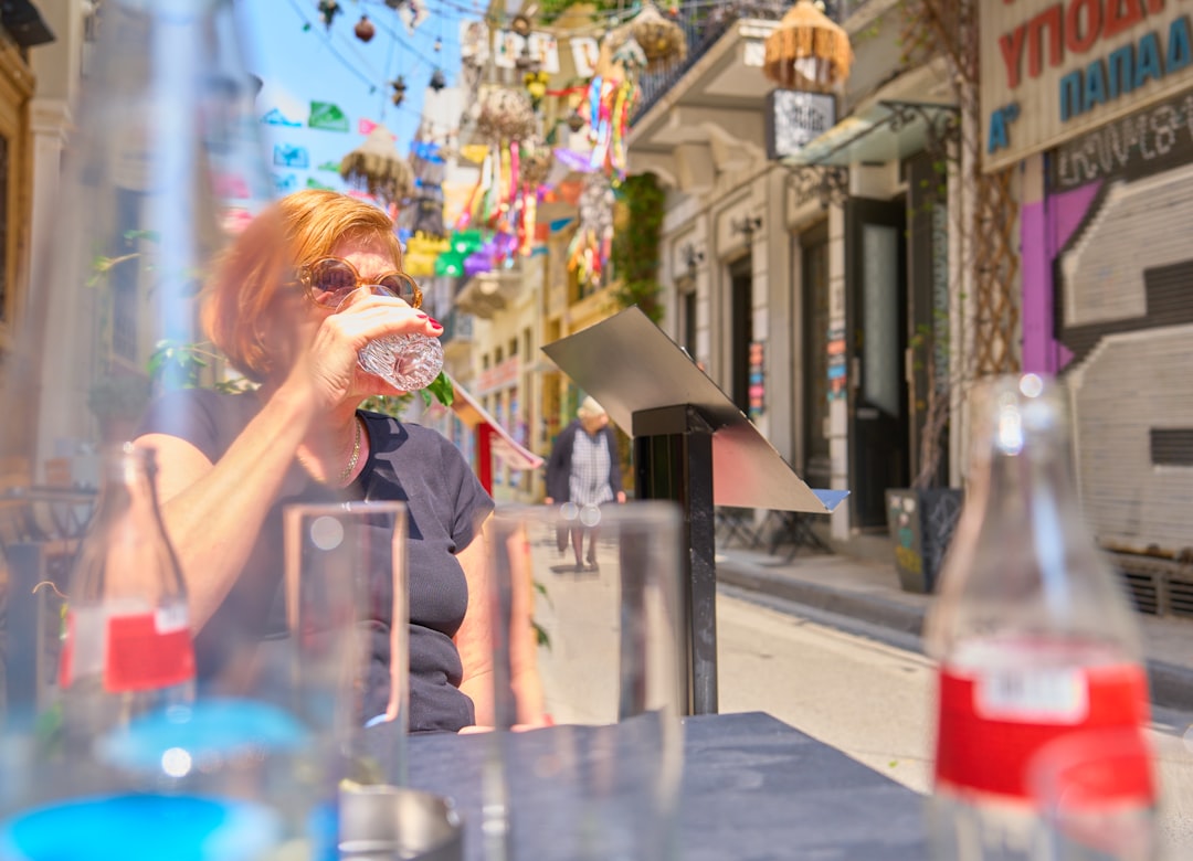 woman drinking water outdoors after exercise