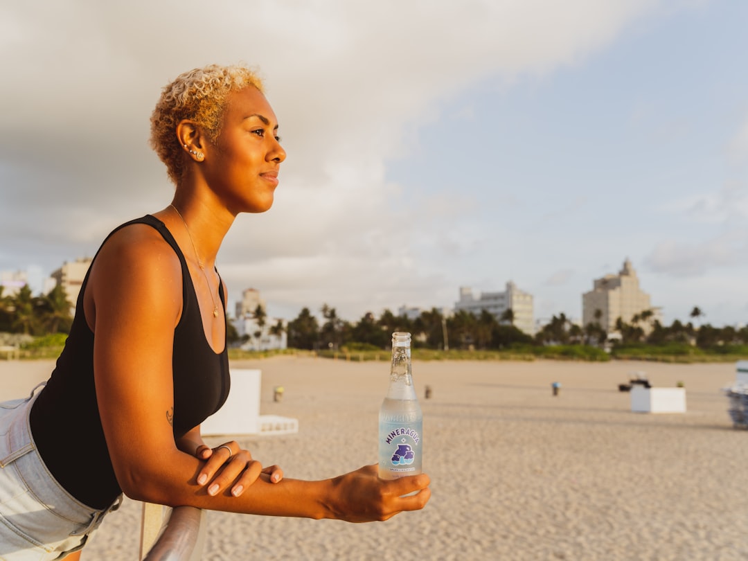 Woman runner staying hydrated with water bottle during hot weather