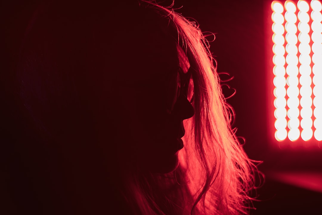 Woman using a red light therapy device at home