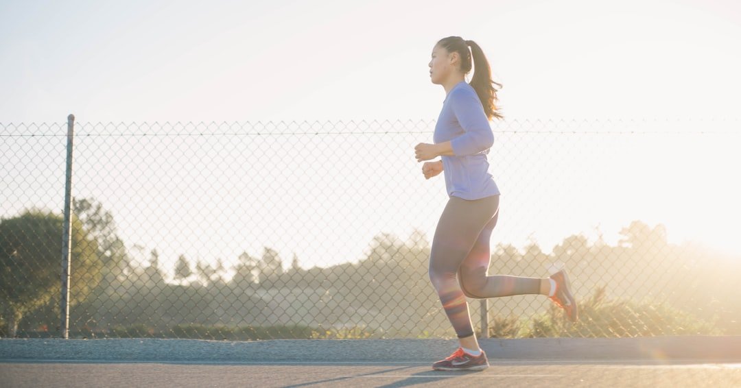 Woman wearing wireless earbuds while exercising outdoors