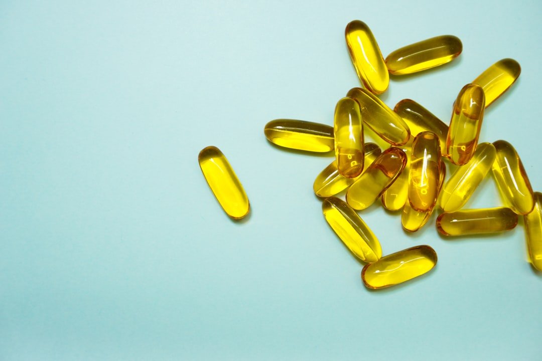 Fish oil omega-3 supplement capsules with glass of water