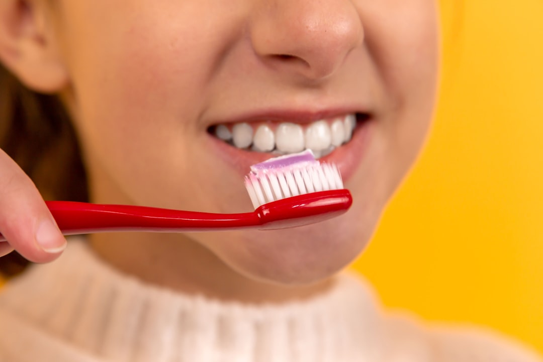 Woman brushing teeth with sonic toothbrush
