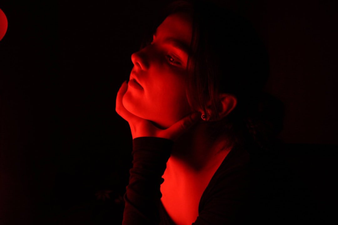 Woman using red light therapy on her face
