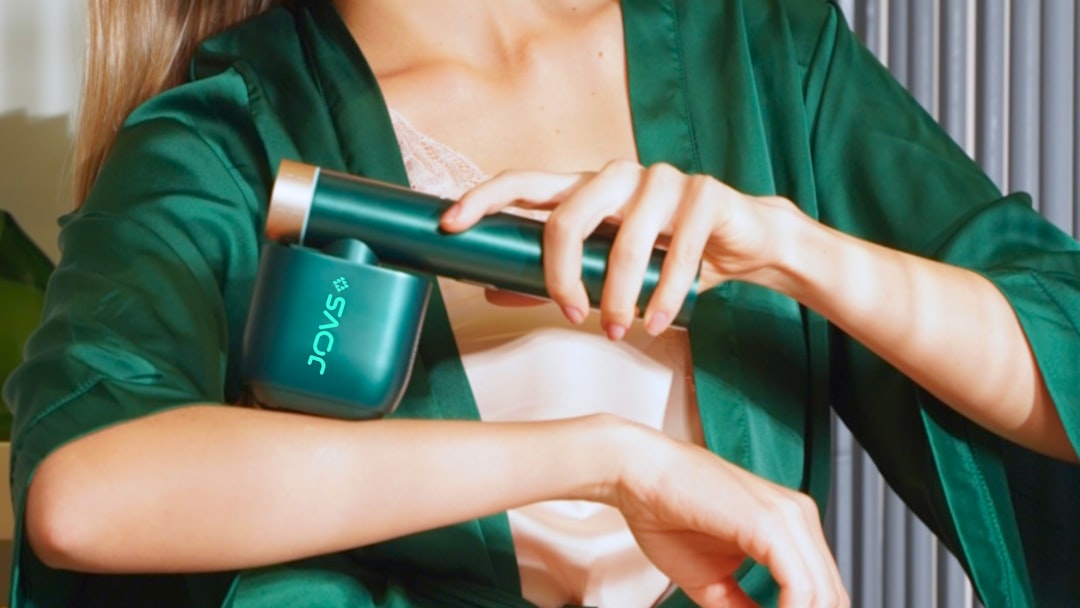 Percussion massage gun being used on muscles for recovery