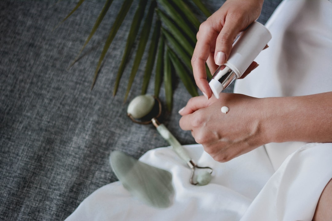 Hands applying topical cream to skin