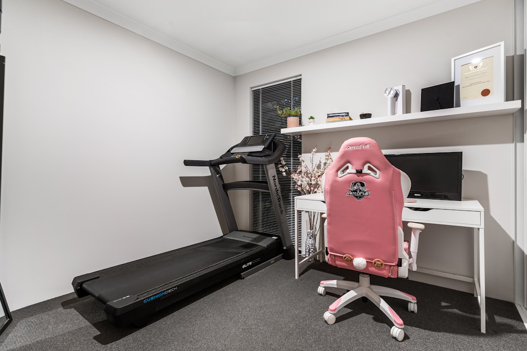 Walking pad treadmill positioned under a standing desk in a home office