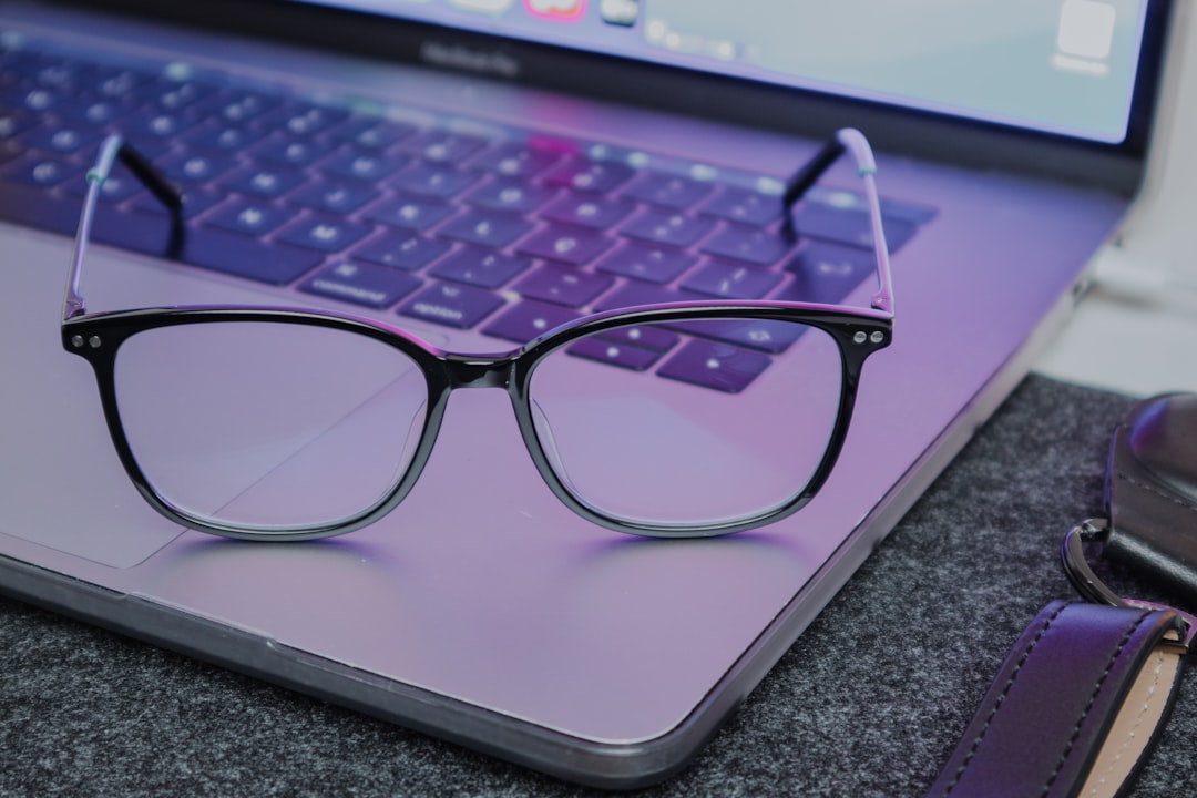 Blue light blocking glasses resting beside a laptop at night