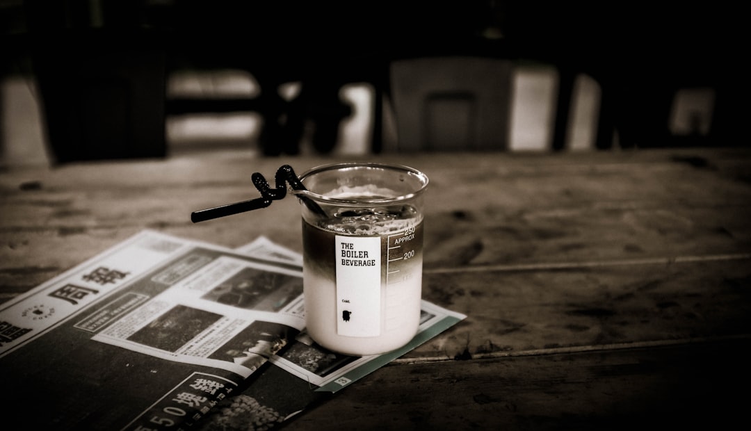 A handheld milk frother whisking a warm drink