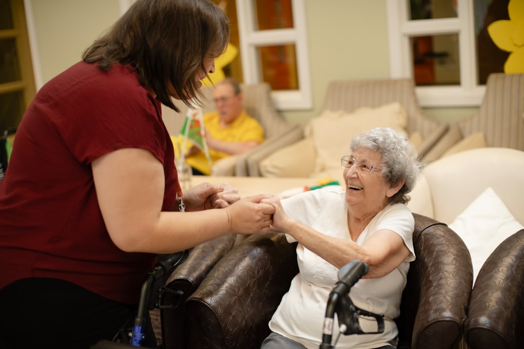Older adult and caregiver smiling together during a home health check