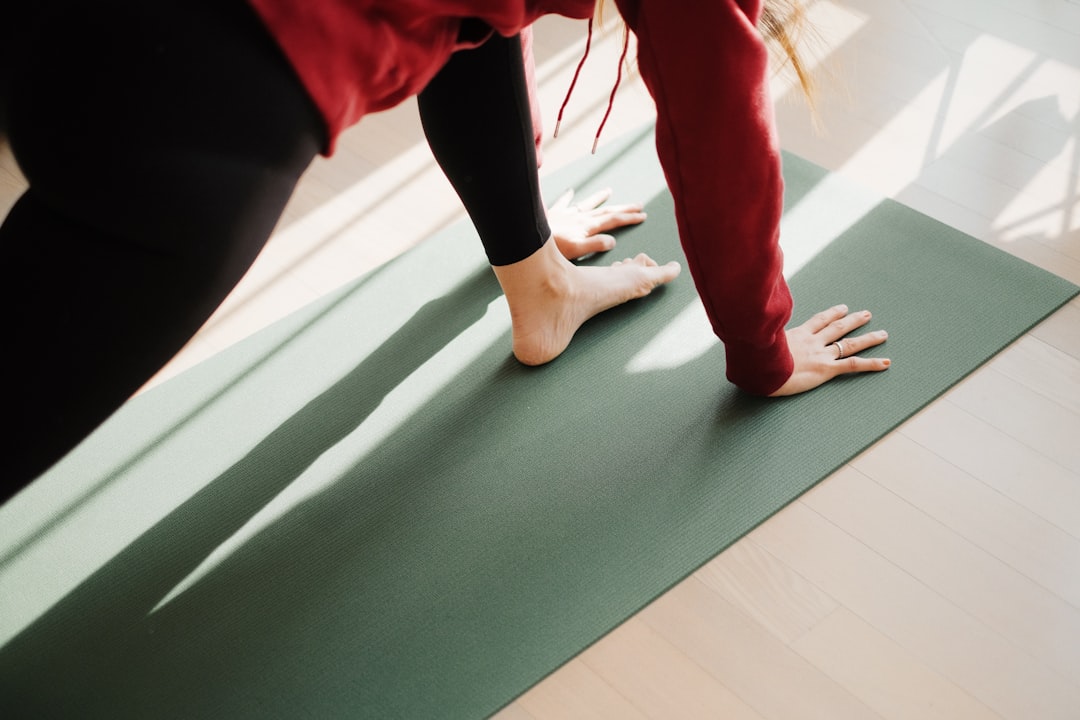 Woman stretching on a yoga mat in morning light