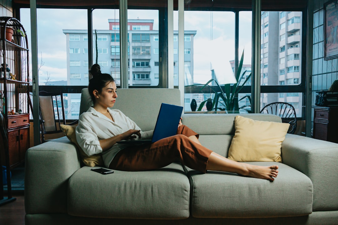 Woman relaxing on her couch in a bright living room while winding down at home