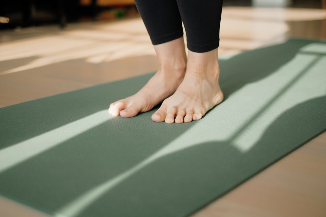 Person wiping down and cleaning a yoga mat