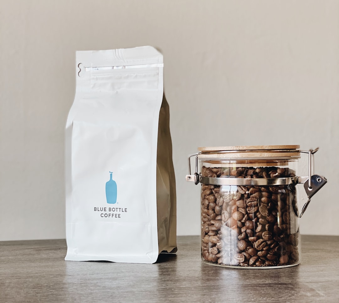 Bag of coffee beans and a jar on a kitchen counter in morning light