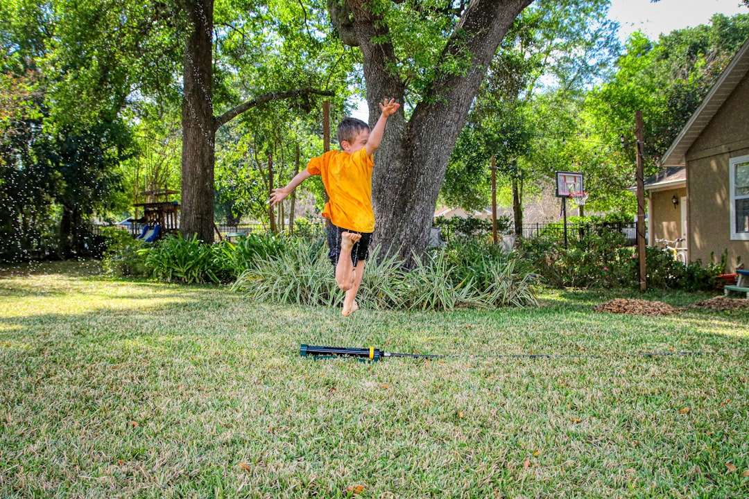 Kid practicing balance barefoot on a backyard slackline