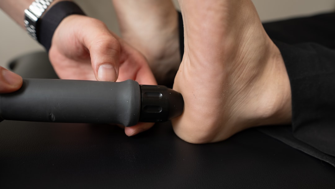 Percussion massager applied to shoulder muscle