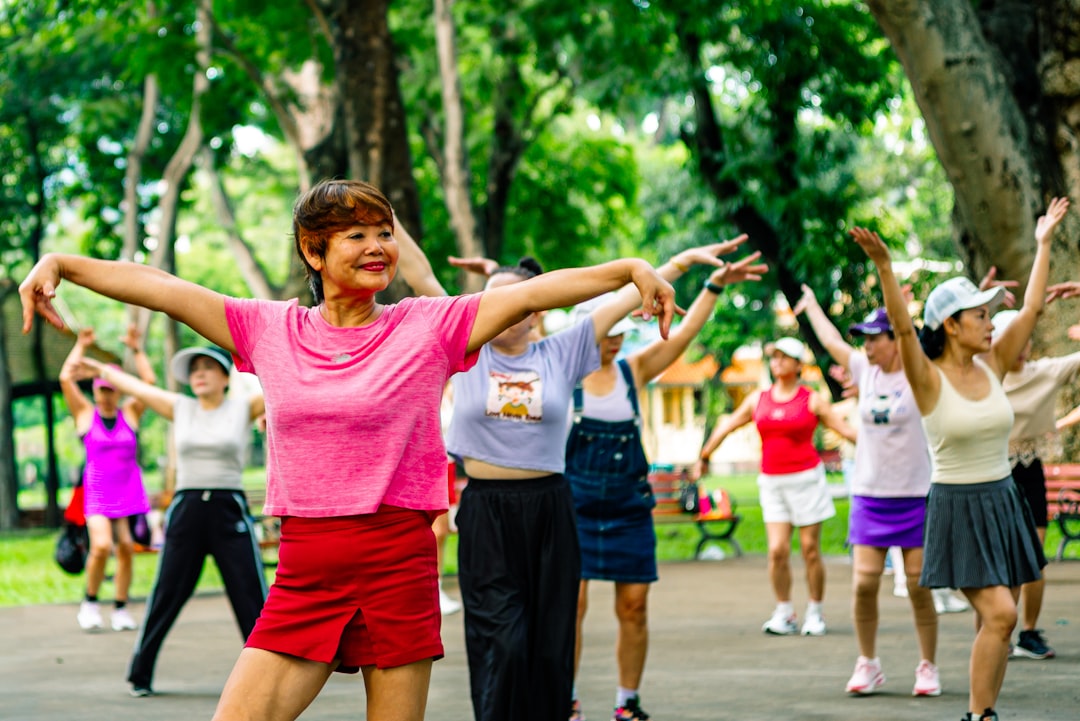 Group of older adults exercising together outdoors in a park