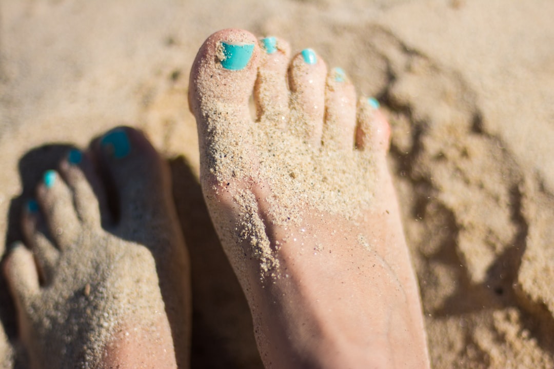 Bare feet in sand — strong healthy feet are the foundation of balance
