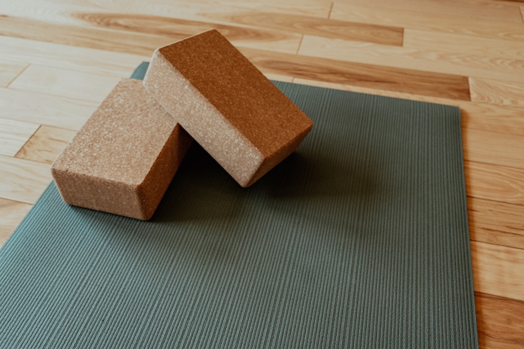 Cork yoga blocks resting on a green yoga mat