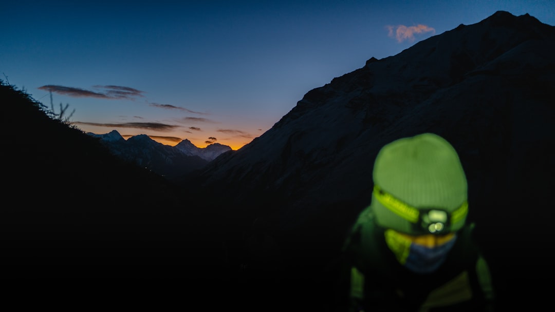 Runner wearing a headlamp on a dark forest trail