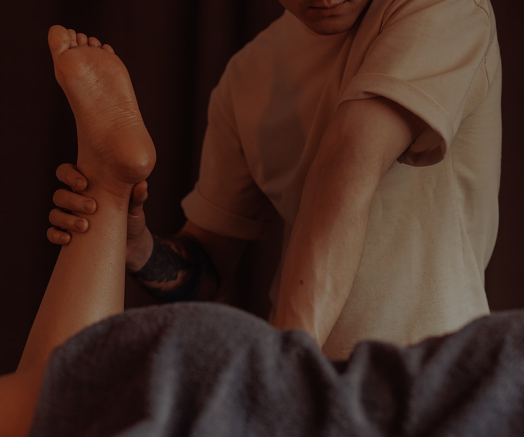 Athlete using massage gun on leg muscles after training