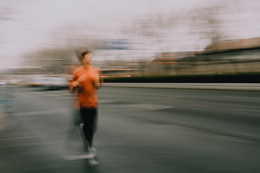 Motion-blurred runner pushing hard along a city street