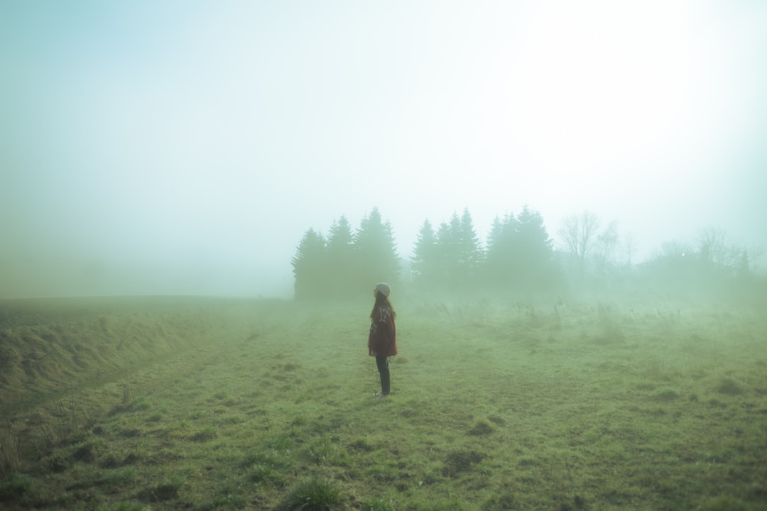 Runner moving through fog on a dim autumn morning road