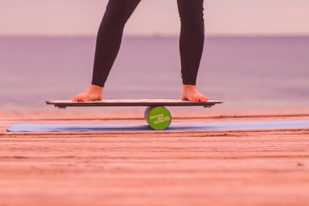 Standing barefoot balance practice on a wooden wobble board
