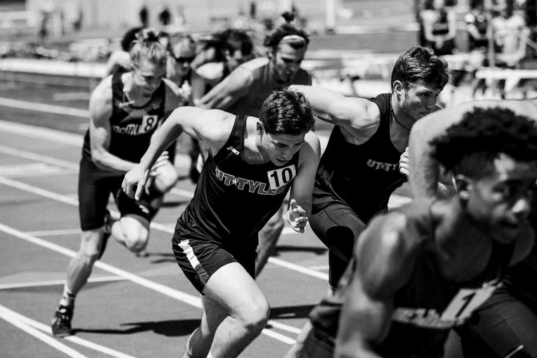 Athletes sprinting around an outdoor track during competition