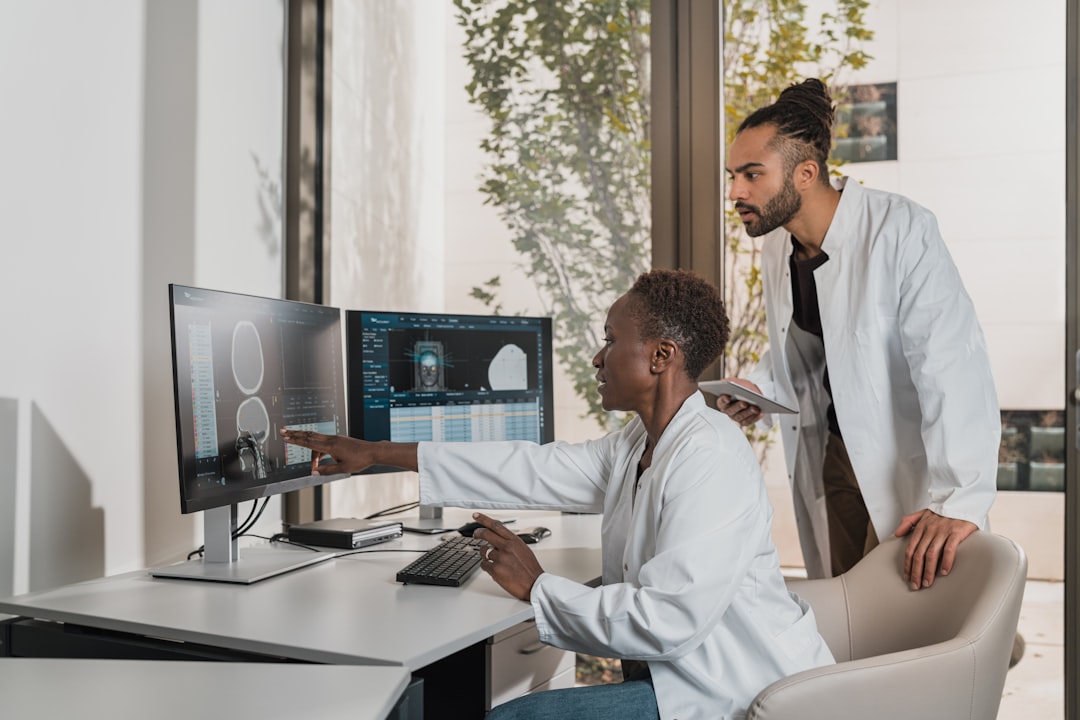 Two medical professionals reviewing bone density scans on monitors