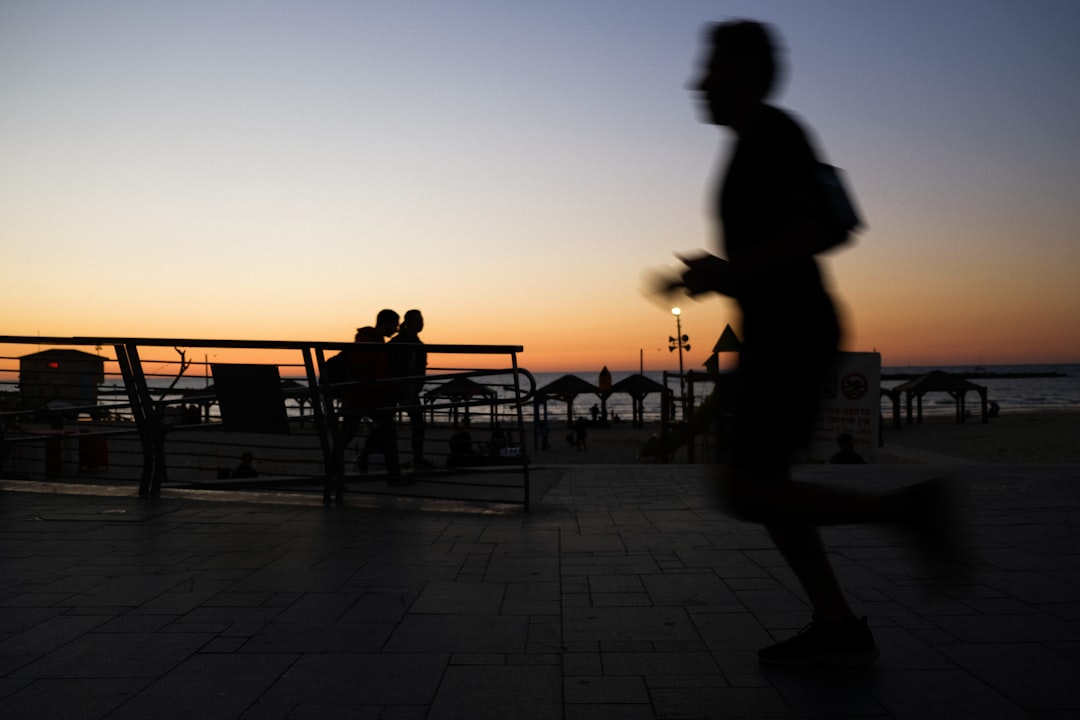 Silhouetted runner on a promenade at dusk
