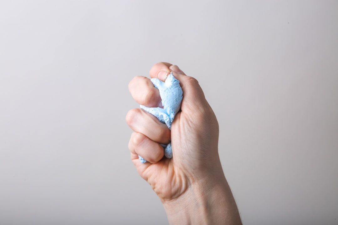 Squeezing soft therapy putty to warm up hand and forearm muscles