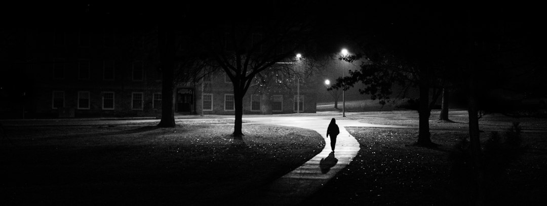 A walker on a lit path after dark