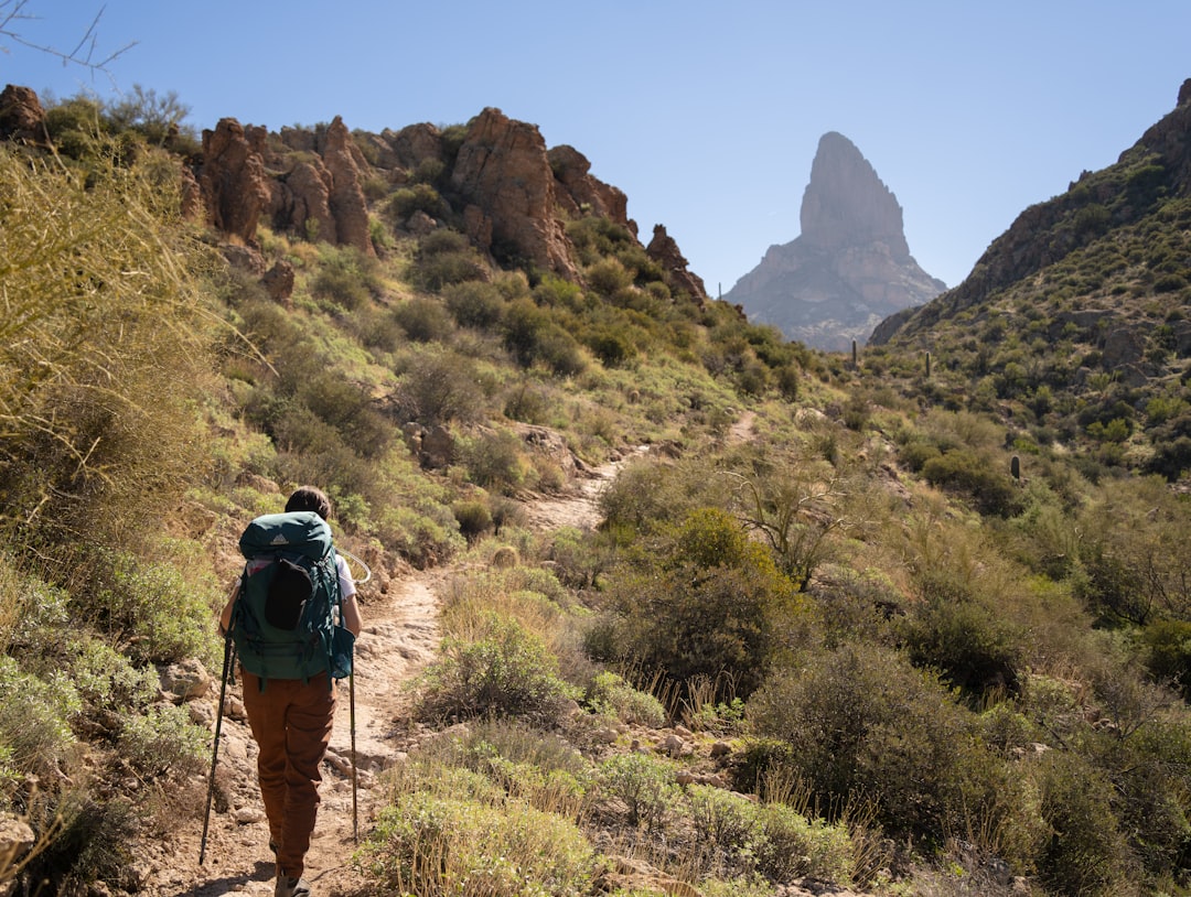 Woman hiking a desert trail wearing a loaded backpack