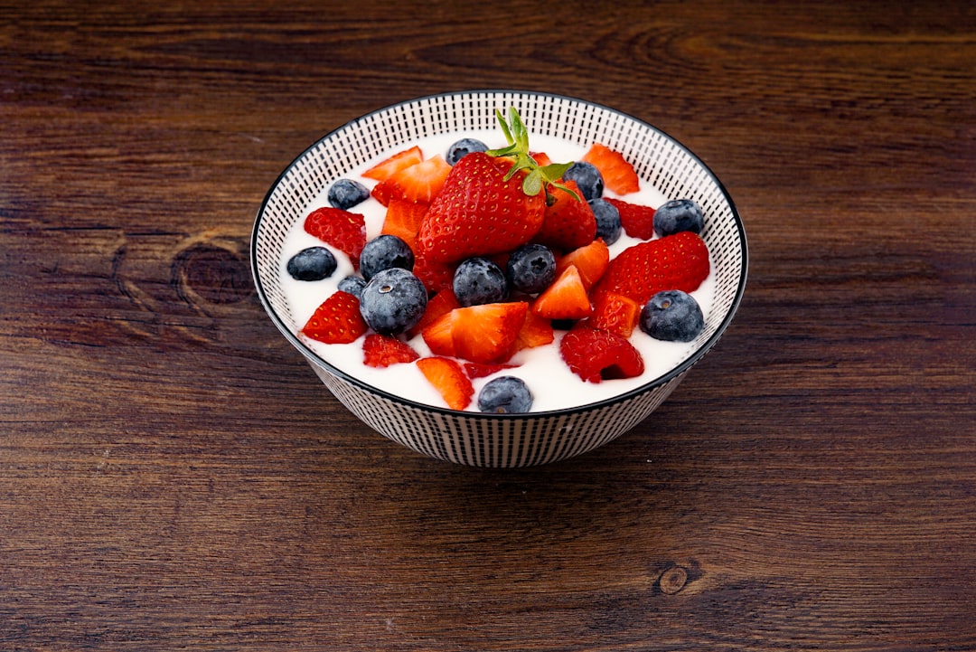 Bowl of Greek yogurt topped with strawberries and blueberries