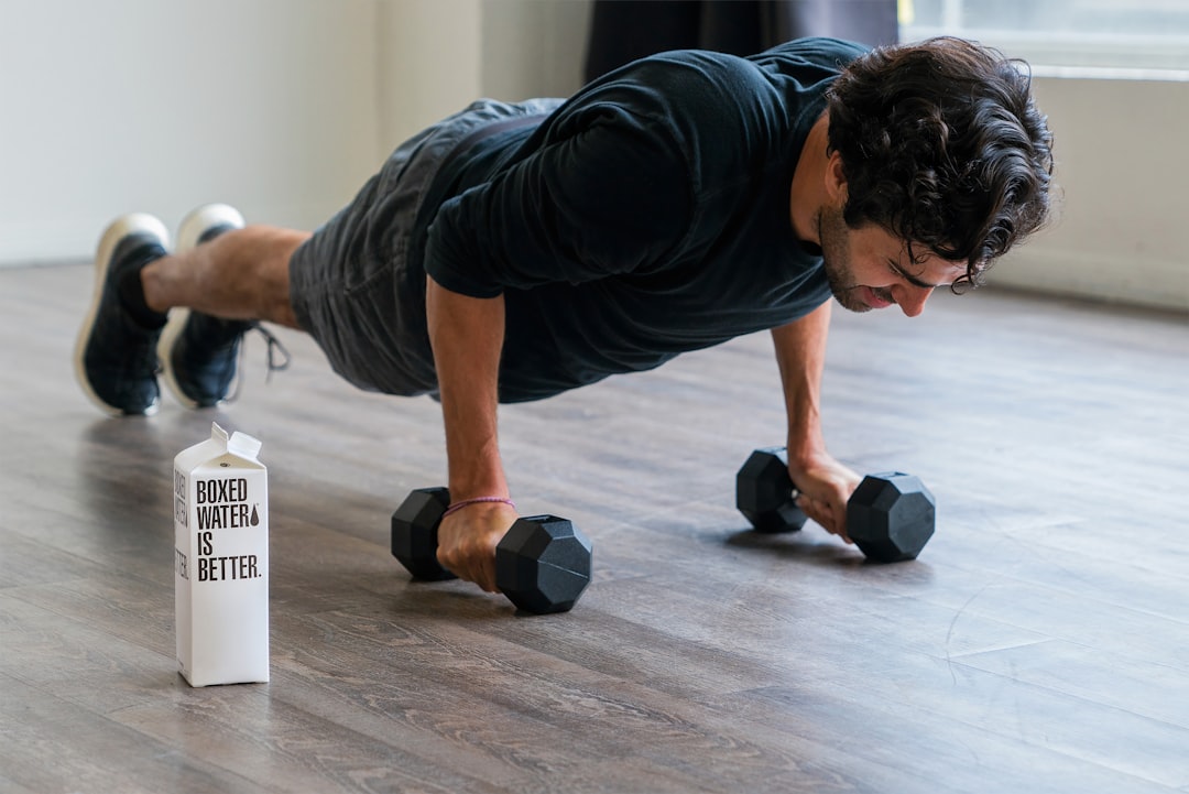 Man holding a plank position on a wooden floor