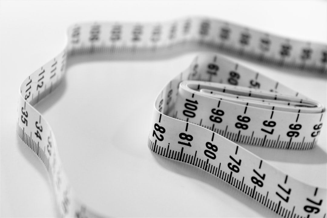 A measuring tape coiled on a counter, the cheapest honest body-composition tool