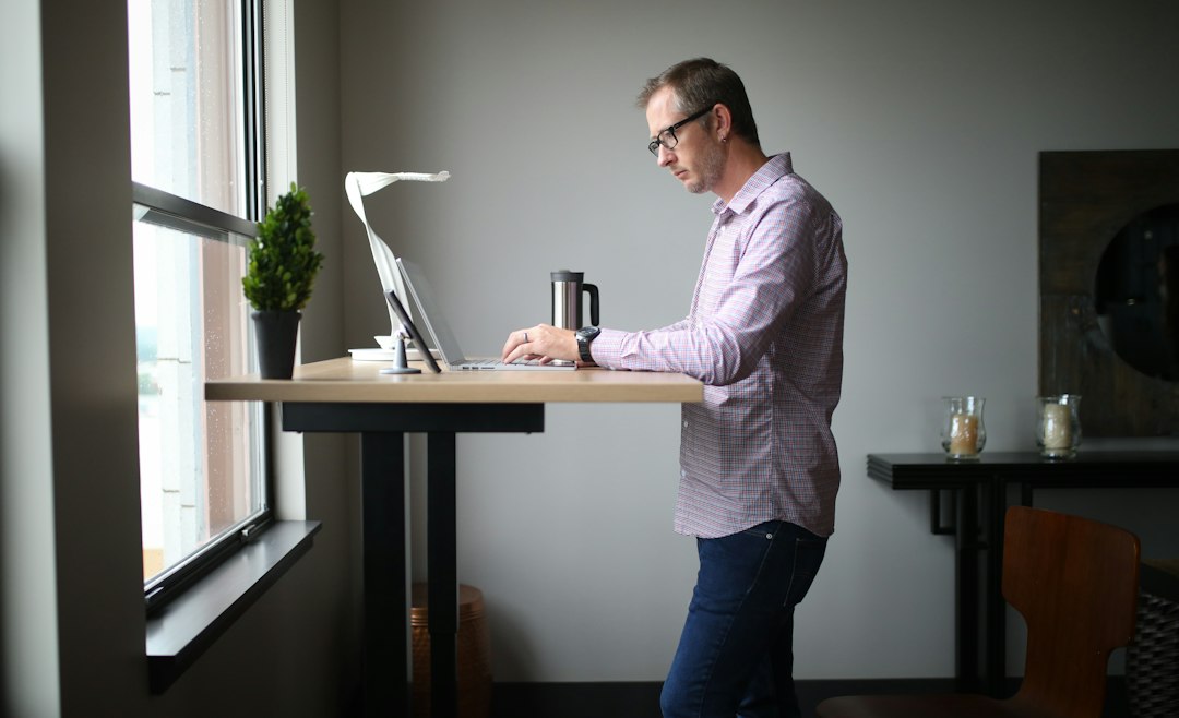 Man working at a standing desk near a window
