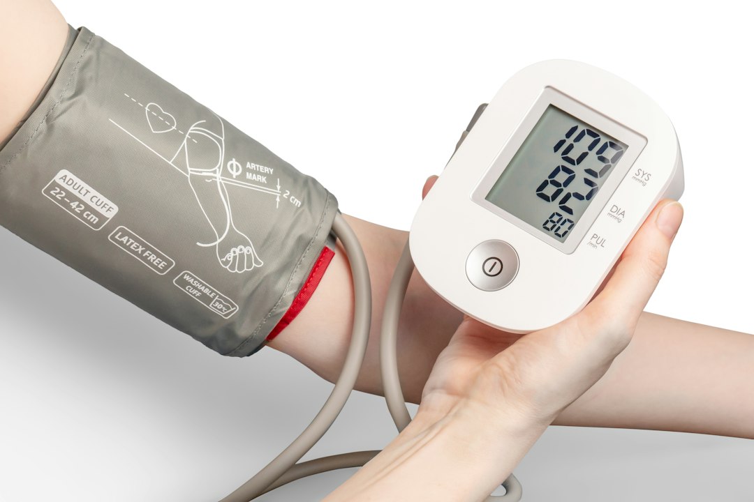 Home blood pressure monitor showing a reading on an upper arm