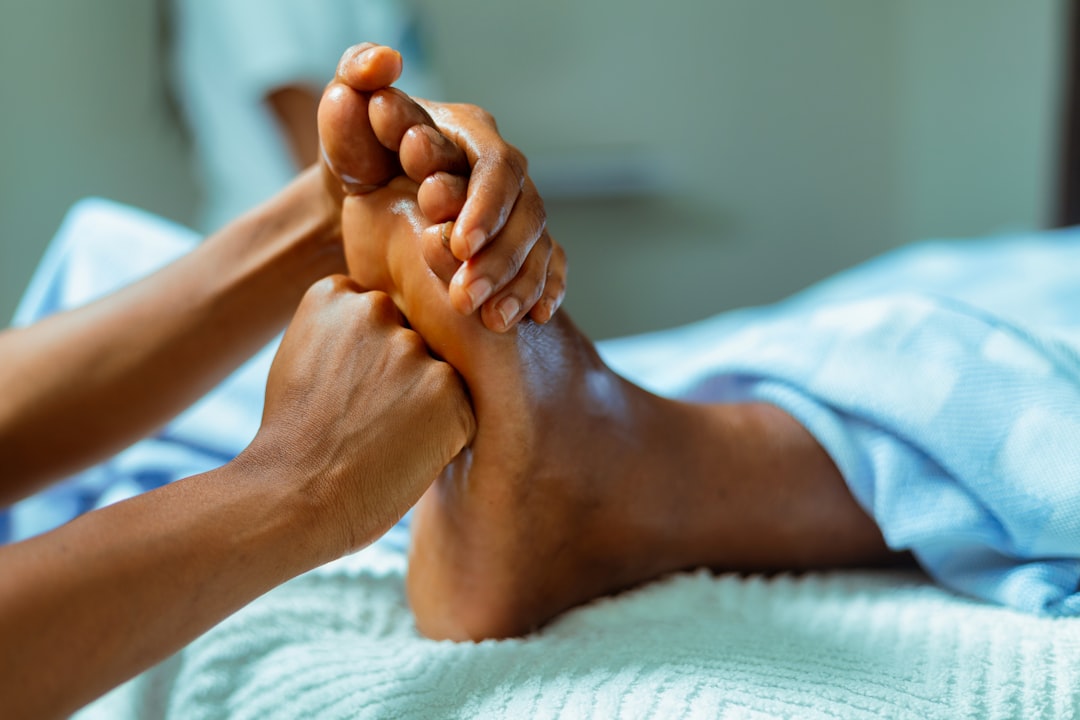 Physical therapist performing an arch massage on a patient's foot