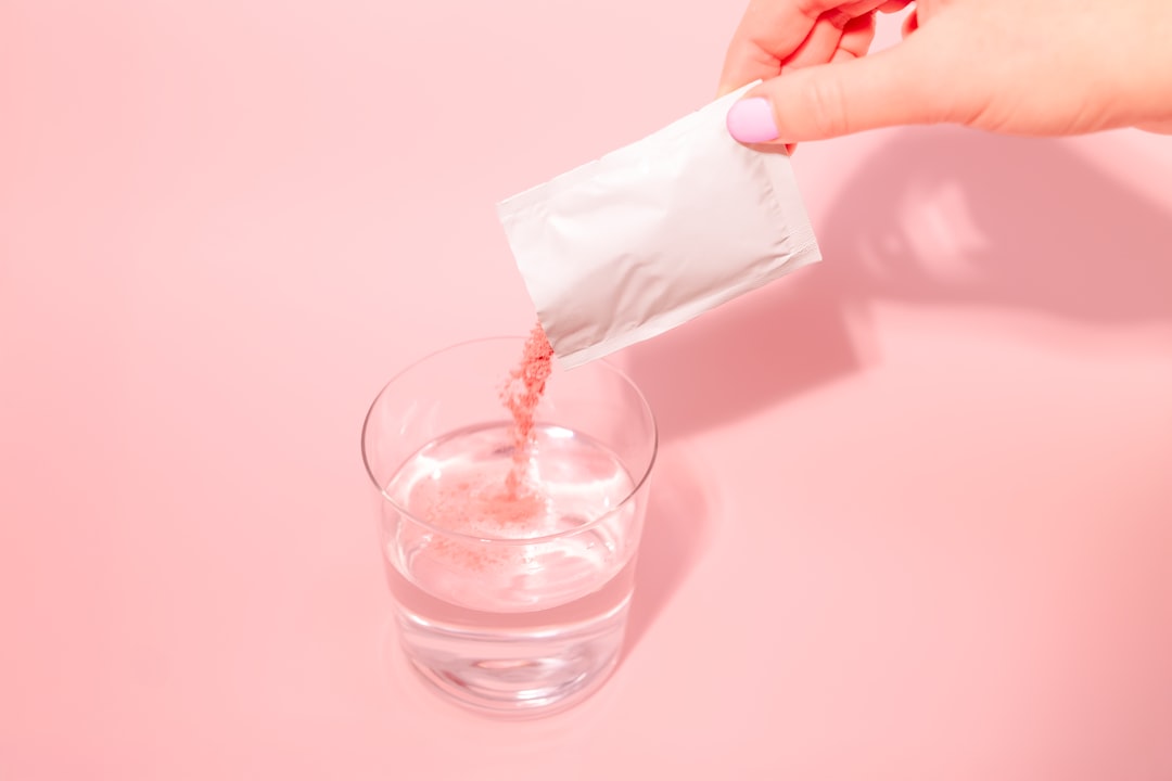 Pouring hydration drink mix powder into a glass of water