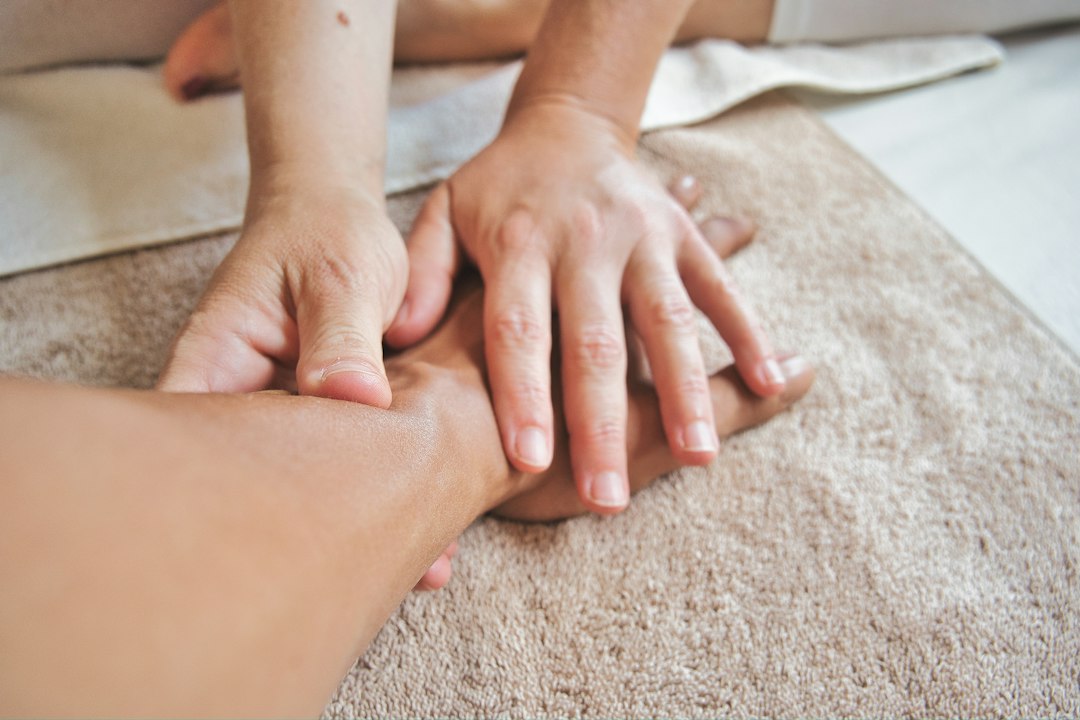 Relaxing foot massage performed on a soft towel in a warm spa-like setting