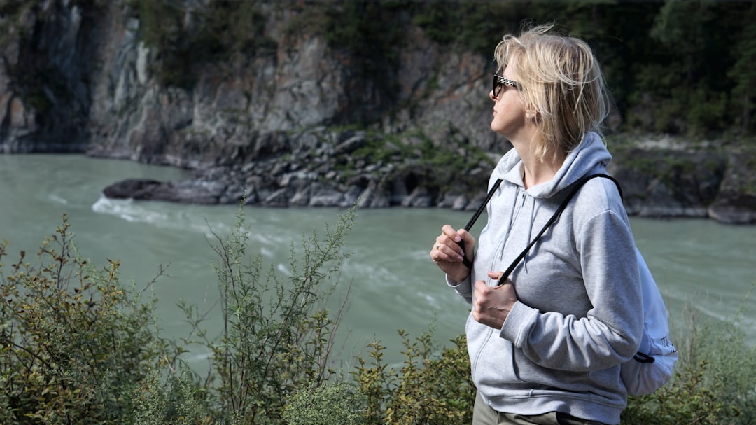 Woman in her fifties pausing by the river after a morning session