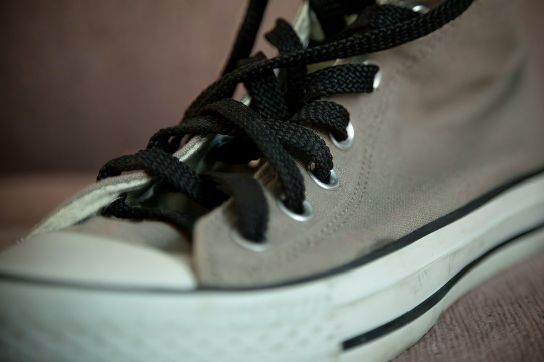 Close-up of a sneaker with laces being adjusted for fit
