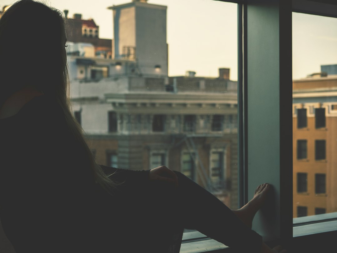 Woman sitting quietly by a window in soft dawn light