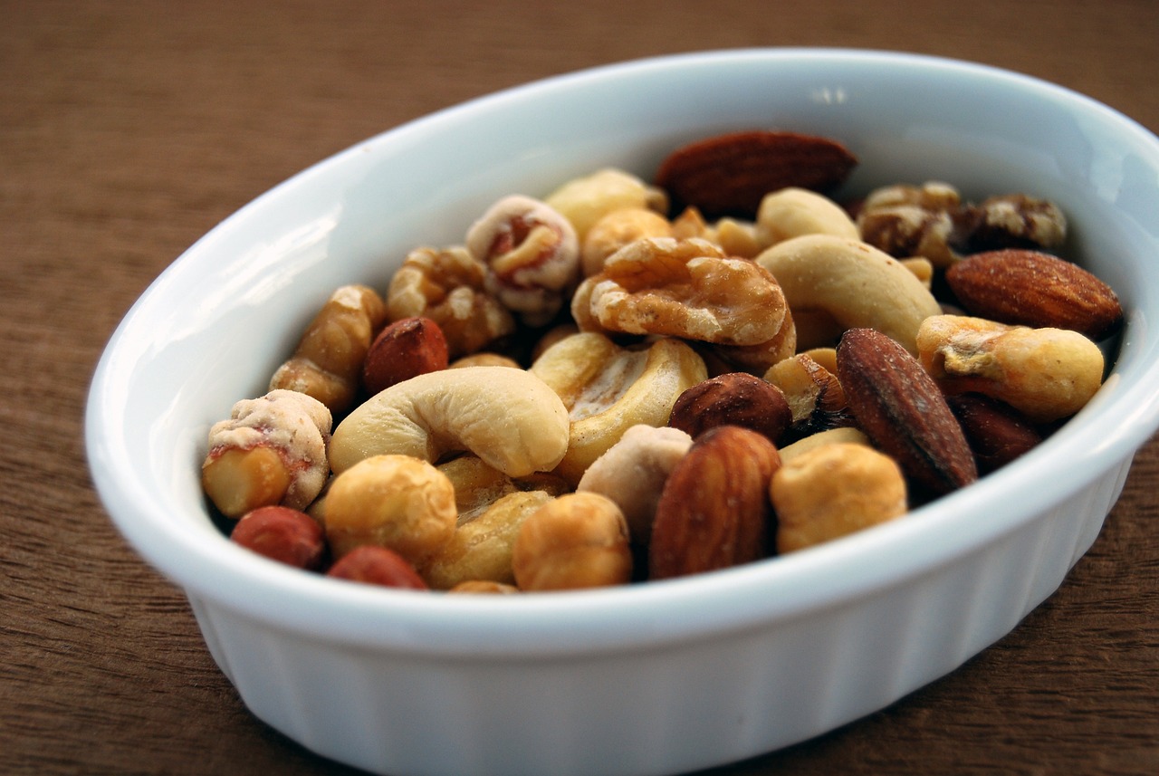 White dish filled with mixed almonds, cashews, and walnuts